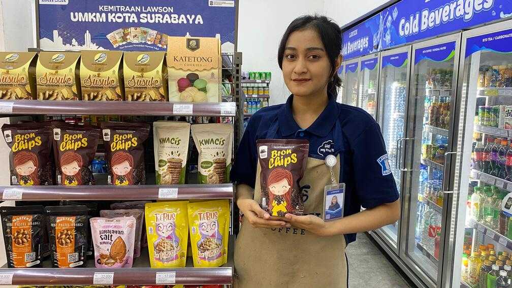 Kru toko Lawson Dharmahusada, Surabaya, menunjukkan produk Bronchips di rak khusus produk UKM Kota Surabaya. Sejak dipasarkan awal tahun 2024, Bronchips menjadi salah satu produk UKM yang paling banyak terjual di Lawson yang ada di Surabaya. 